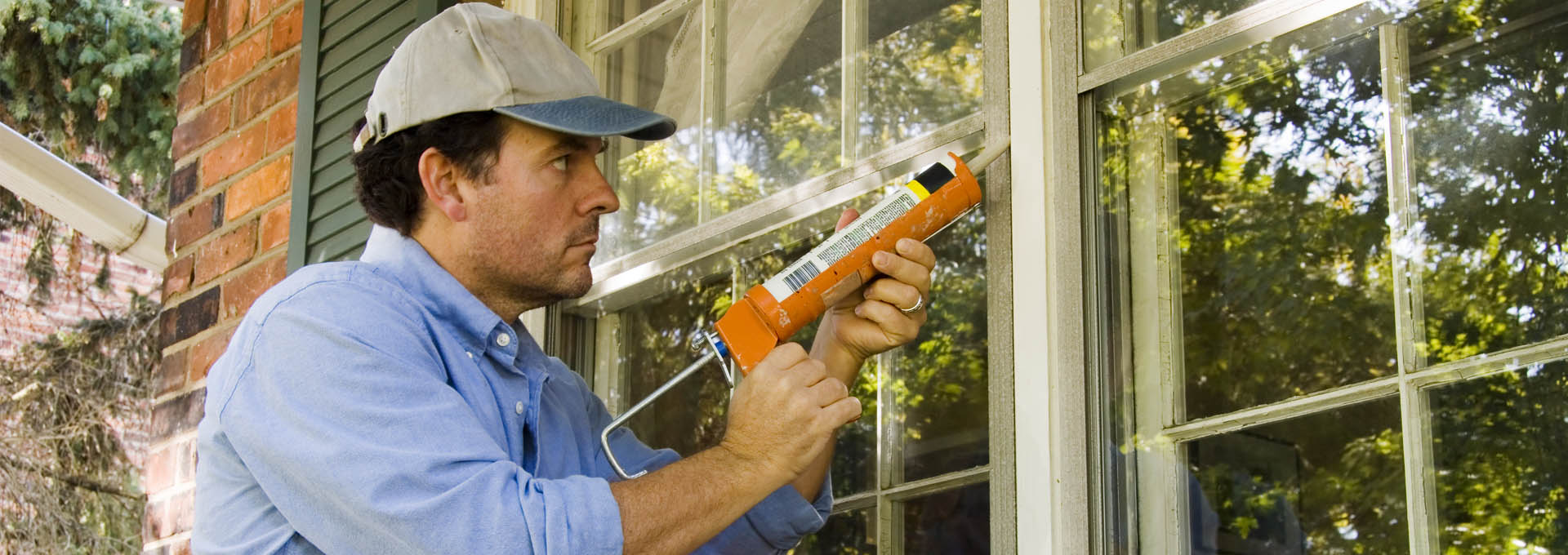 Man Caulking Window